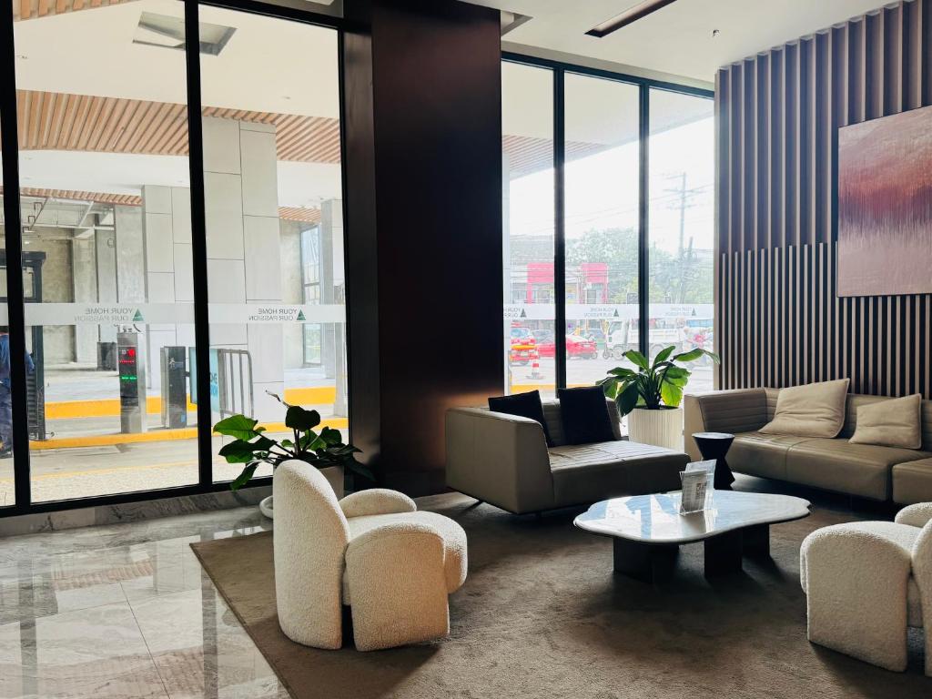 vestíbulo con sofás, mesa y ventanas en ARC Towers Condominium, en Cebú