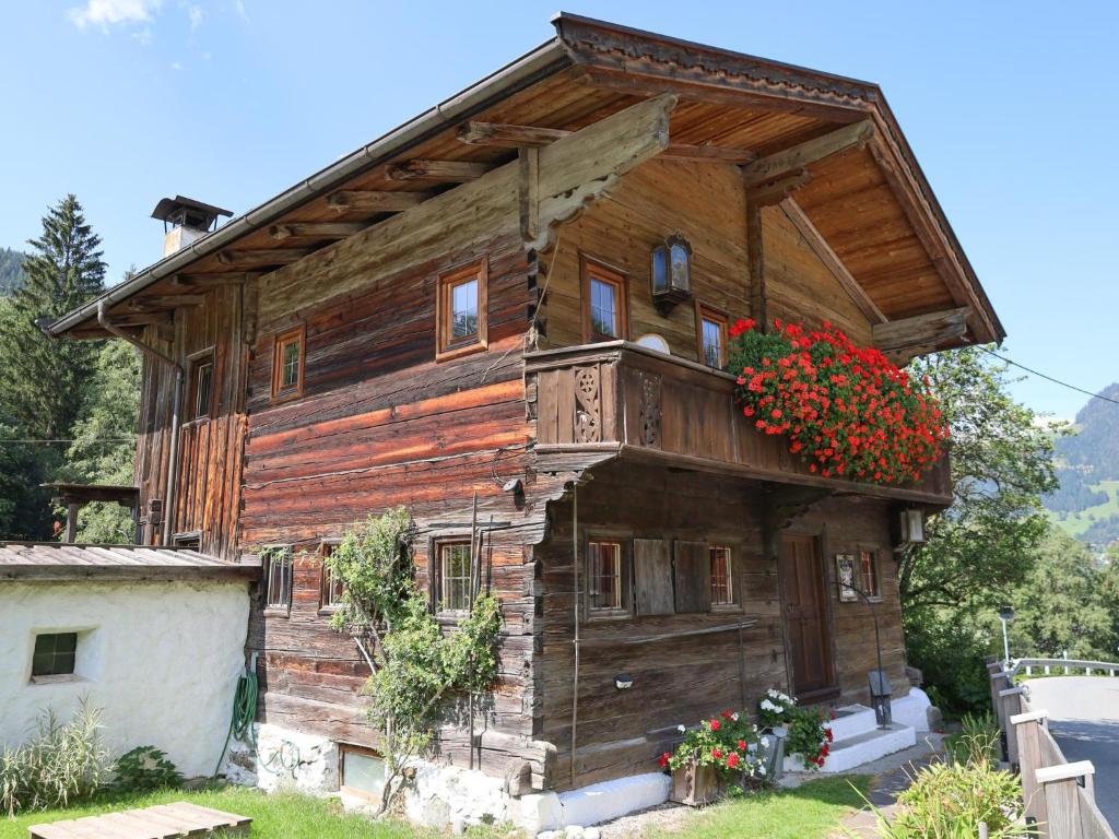 an old wooden house with flowers on it at Kupferhäusl in Alpbach