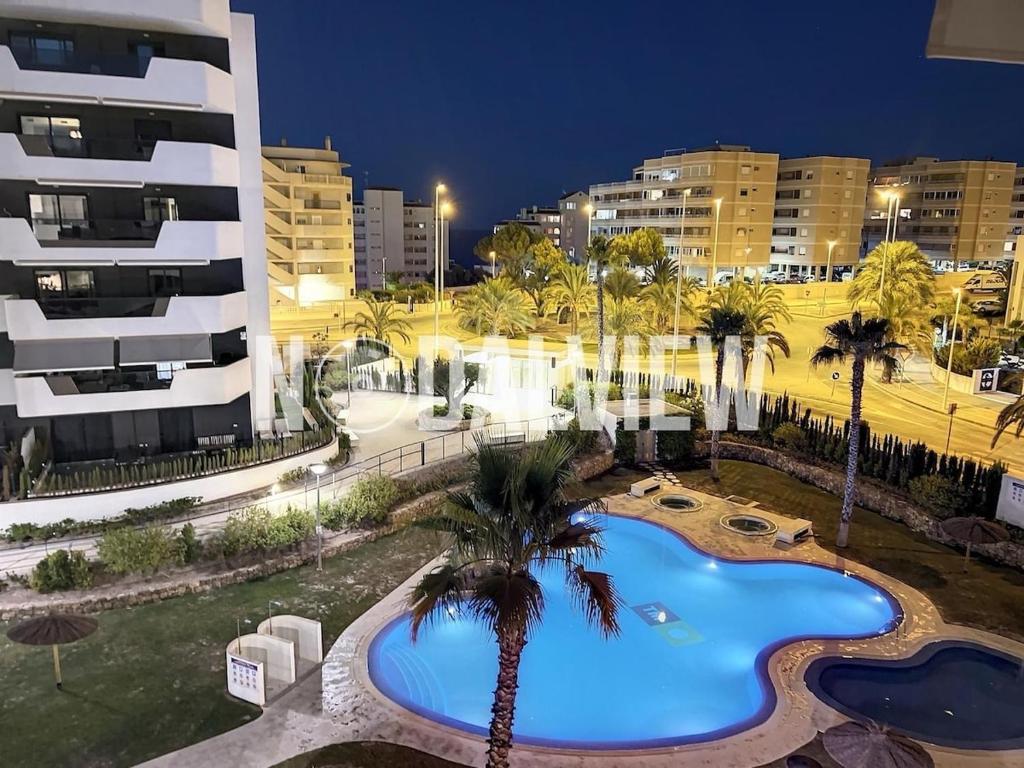a large swimming pool with palm trees next to a building at Arenales SLB in Arenales del Sol