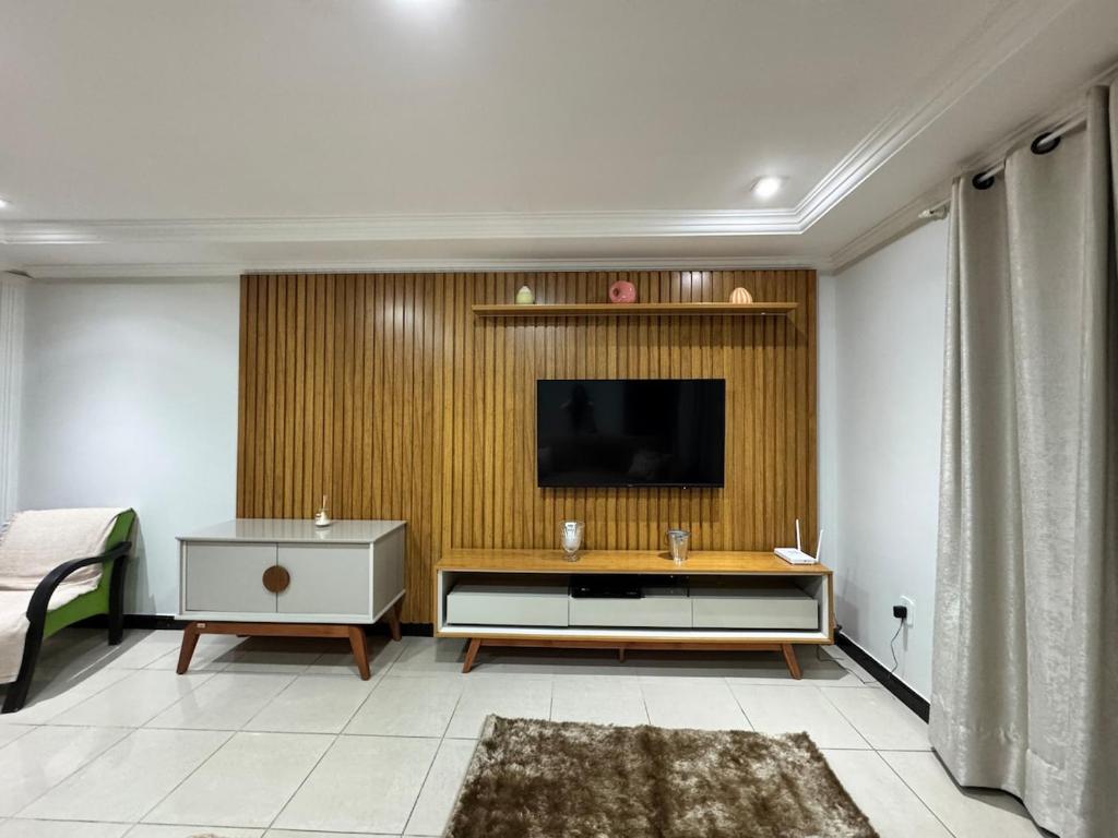 a living room with a television on a wall at Lar das Montanhas - 3 quartos até 8 pessoas in Marechal Floriano