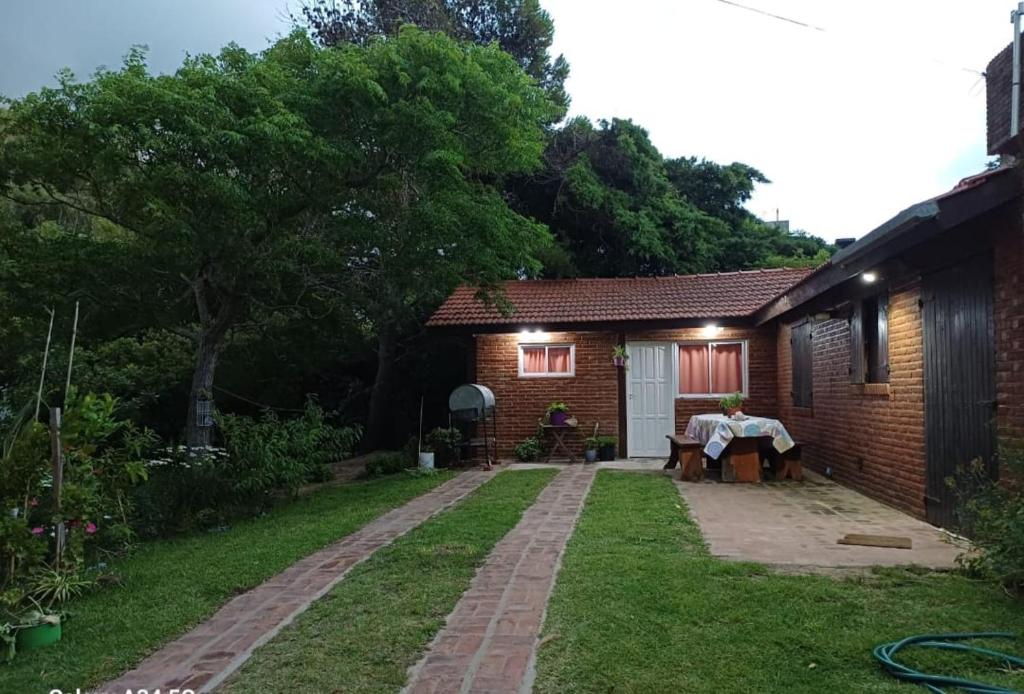 Un patio trasero con una casa de ladrillo y una mesa y una mesa. en Departamento Pinamar Ostende, en Ostende