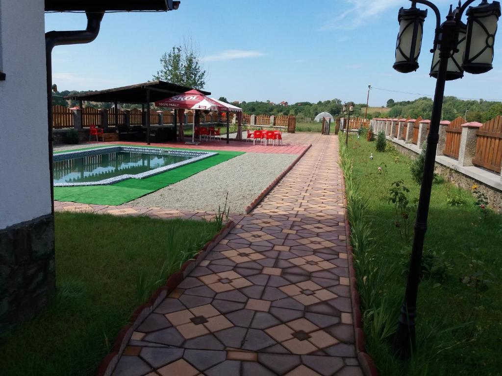 a walkway next to a pool in a yard at Casa Robi in Peştişani