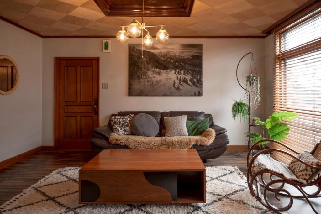 uma sala de estar com um sofá e uma mesa de centro em NIKI HOUSE -Yoichi 貸切一軒家 em Kurokawamachi