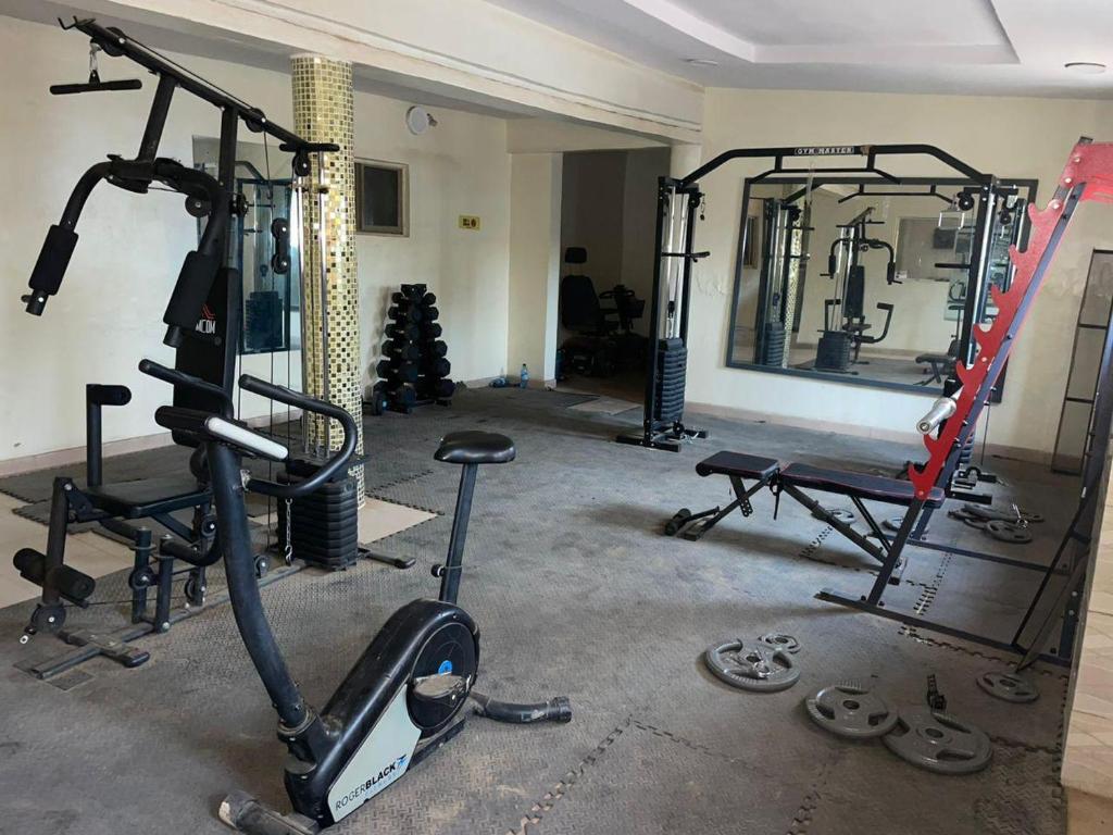 un gimnasio con varias bicicletas estáticas y un espejo en Aso Rock Hotel Bar and Restaurant, en Loburo
