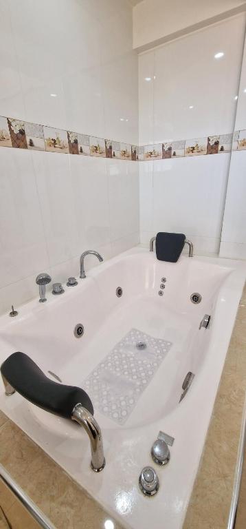 a white bath tub with a faucet in a bathroom at Hospedaje Tunari - Chalet de Lujo con Jacuzzy, Jardin, Horno y Barbacoa a Leña in Quillacollo
