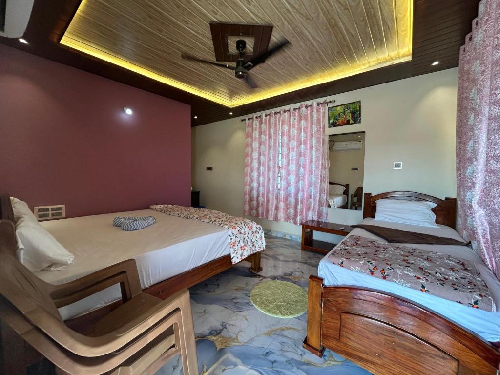 um quarto com 2 camas e um tecto em Hemanth Heritage em Hospet