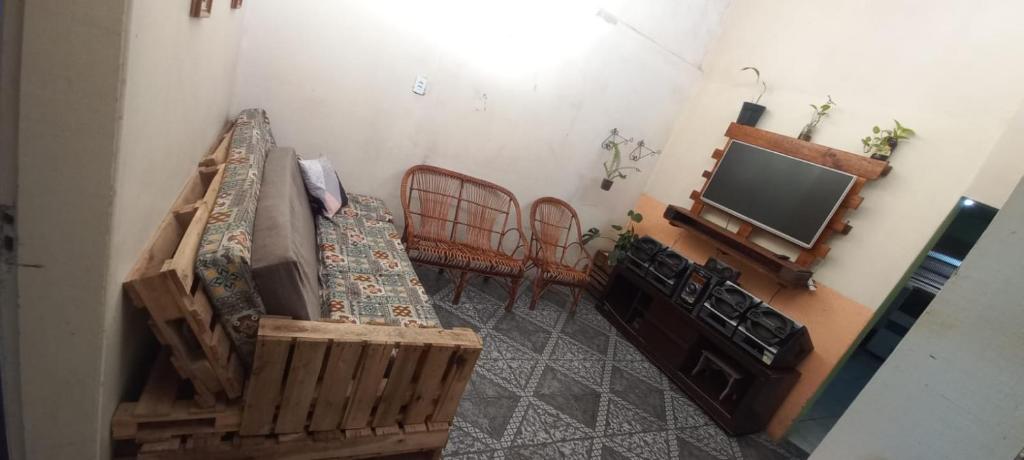 a living room with a couch and a tv at Casa familiar ampla in São Gabriel