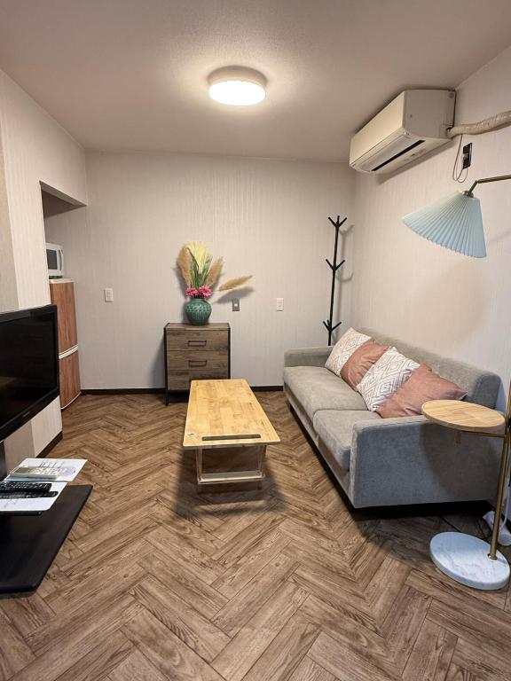 een woonkamer met een bank en een tafel bij star in Osaka