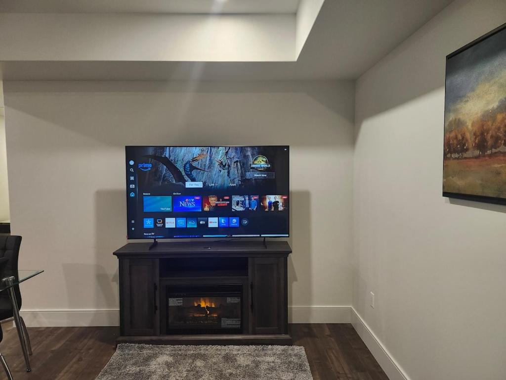 Lakeview Breaktrail Stays في Crosby Island: تلفزيون بشاشة مسطحة فوق مدفأة