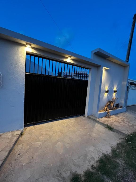 a garage door with lights on a white house at Recanto Lucena - Casa inteira com churrasqueira in Lucena