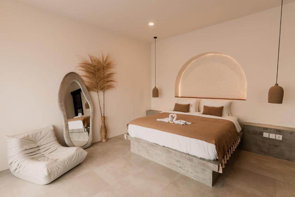 una camera da letto con un letto con specchio e una sedia di Dawn Villa Canggu a Canggu