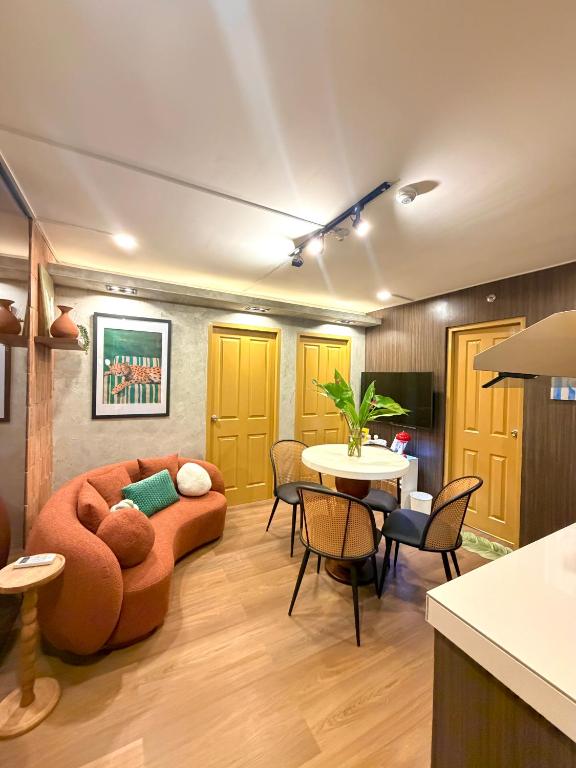 a living room with a couch and a table at House of Keul - 2BR cozy condo in Dumaguete with pool and free laundry for long term guests up to 4 pax in Piapi