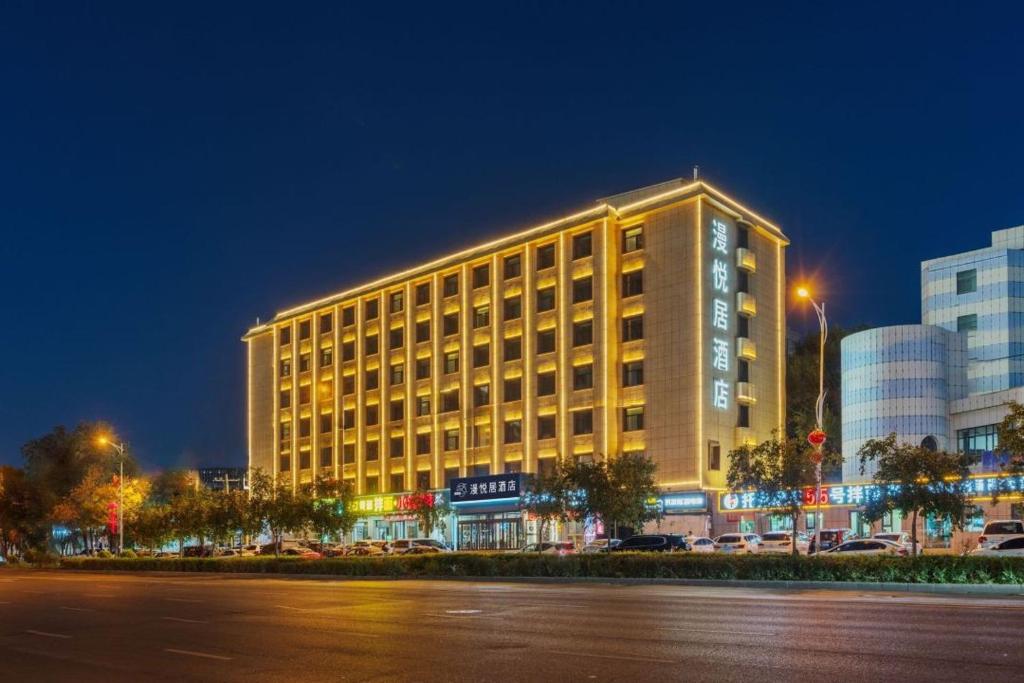 ein großes Hotelgebäude in der Nacht in einer Stadt in der Unterkunft Manyueju Hotel 