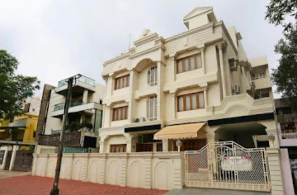 a white building with a fence in front of it at Hotel Vijay Palace in Bhopal