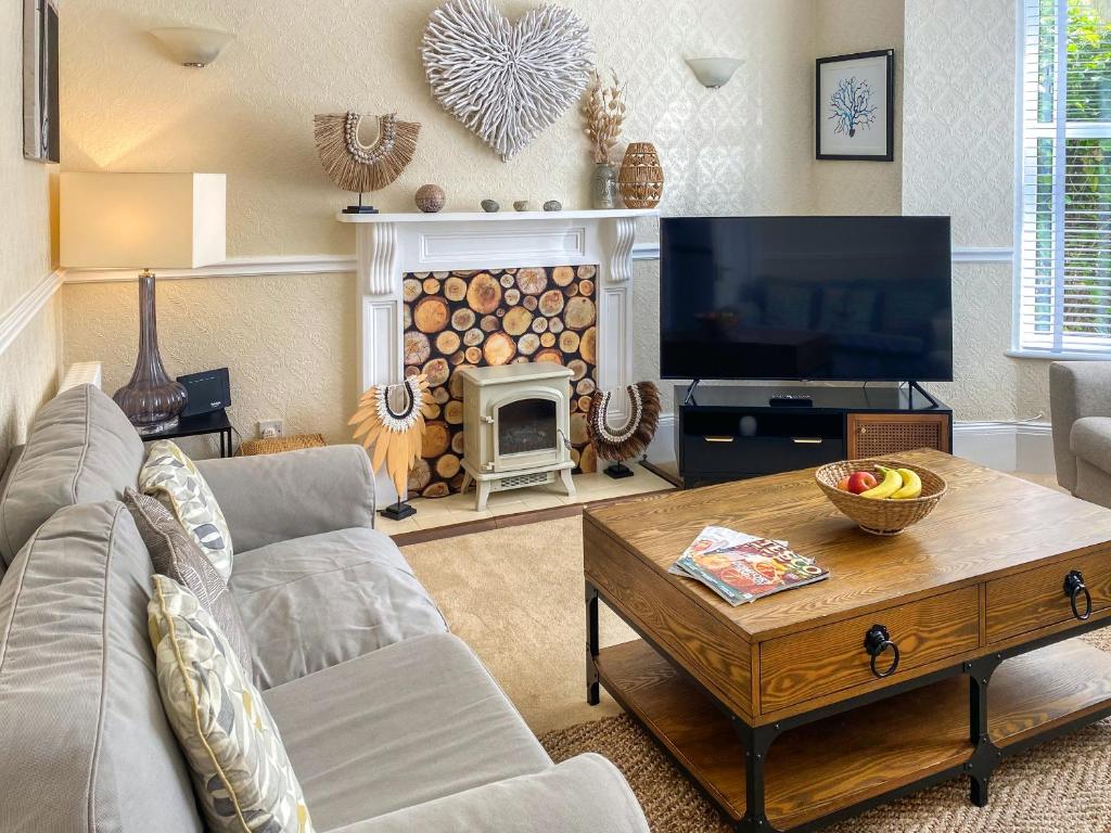 a living room with a couch and a table and a tv at Bora House in Newquay