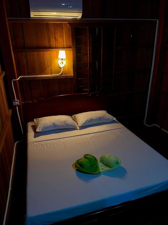 - un lit avec 2 serviettes vertes dans l'établissement Home Stay 1, à Kratie