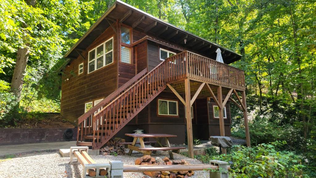 Elk Ridge - cherokee casino GSMNP في Whittier: كوخ في الغابة مع سطح وطاولة نزهة