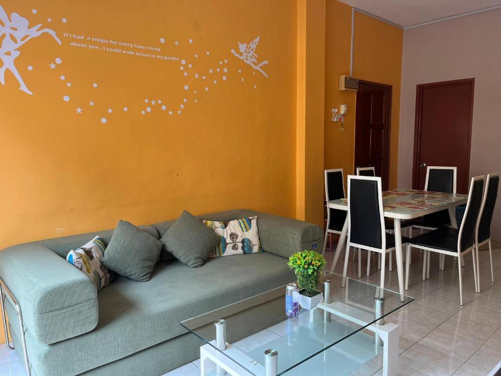 a living room with a couch and a table with chairs at Kelly Cozy cottage in Kampar