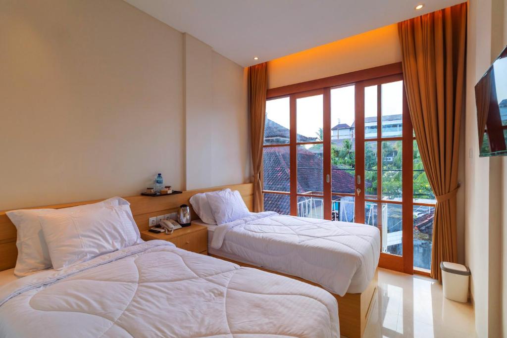 Rúm í herbergi á AA Inn Kuta Beach