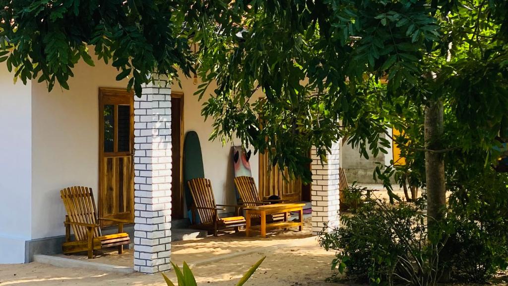 una casa con sedie, tavolo e albero di Solara Arugam Bay ad Arugam
