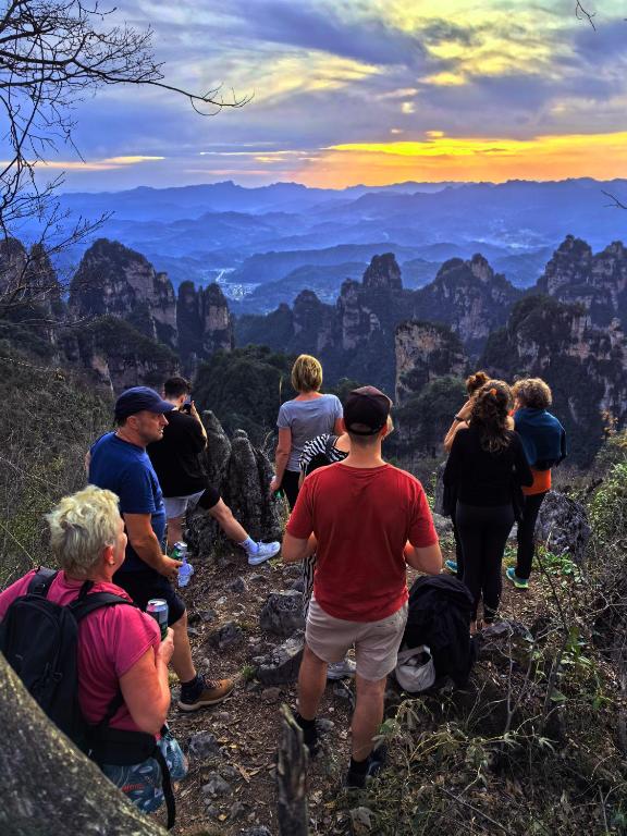a group of people standing on the edge of a mountain at Nature Eco Designer Hotel in Zhangjiajie