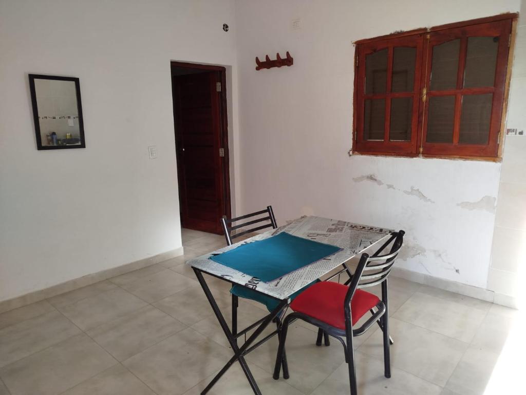einen Tisch mit einem roten Stuhl in einem Zimmer in der Unterkunft Departamento cómodo in La Banda