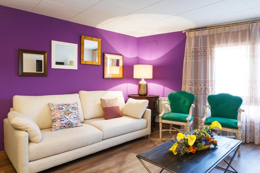 sala de estar con sofá y pared púrpura en Hotel Villa San Jorge, en Azanúy