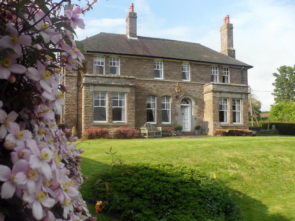 uma grande casa de tijolos com um jardim de relva em Littlebridge House em Bromyard