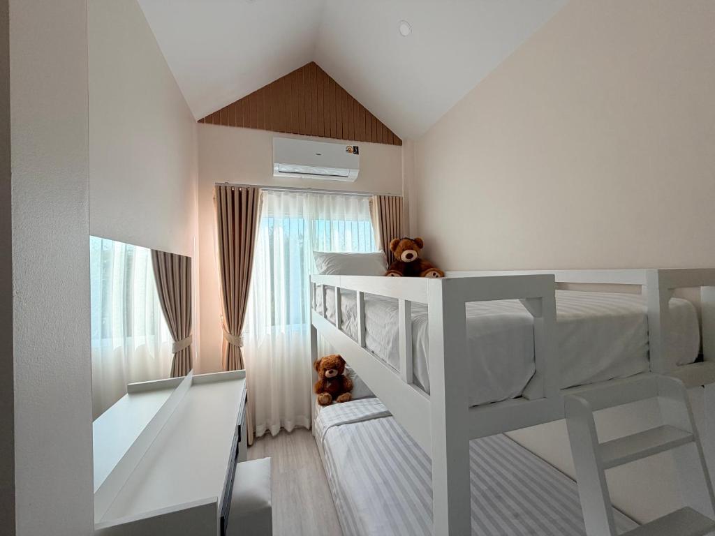a childs bedroom with two bunk beds and a window at Home Hug You in Chiang Mai