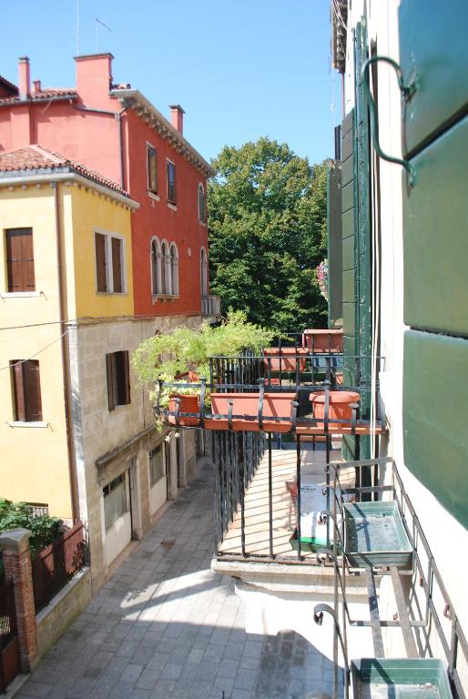 uma varanda com mesas e cadeiras num edifício em Ca' Cino em Veneza