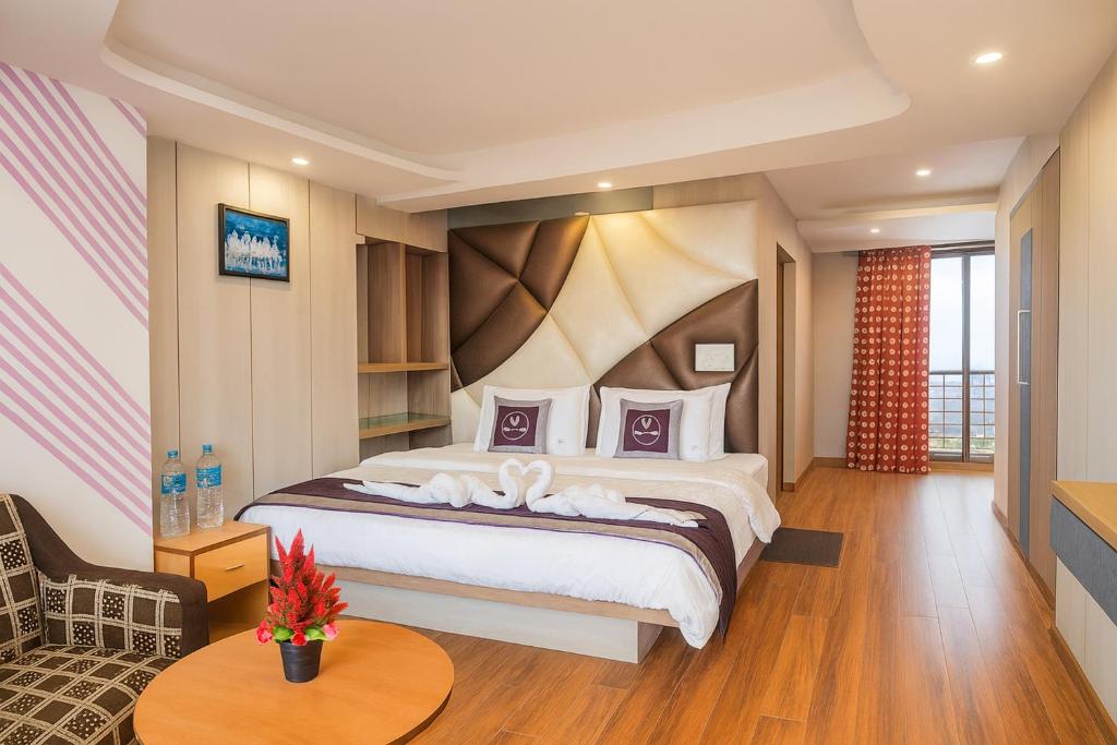 Un dormitorio con una cama grande y una mesa. en The Broadway- Annecy Inn Near Mall Road with -Wi-Fi -Restaurant -Premium &amp; Deluxe Rooms Prime Location - Best Top Rated Hotel In Darjeeling, en Darjeeling