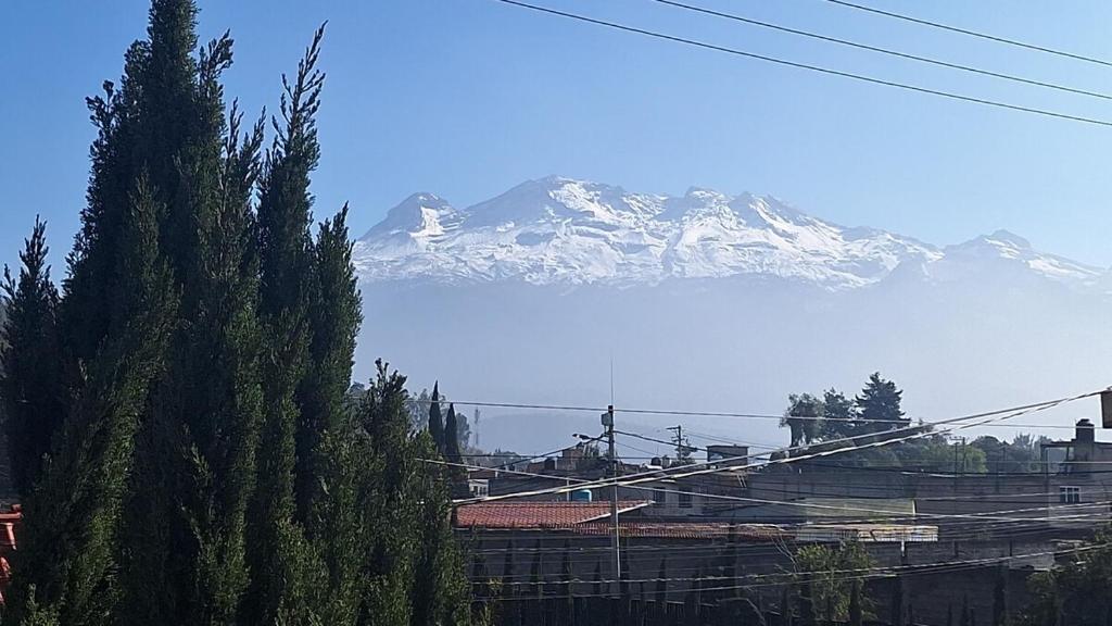 a snow covered mountain in the distance with a mountain at 3- Departamento con terraza in Amecameca de Juárez