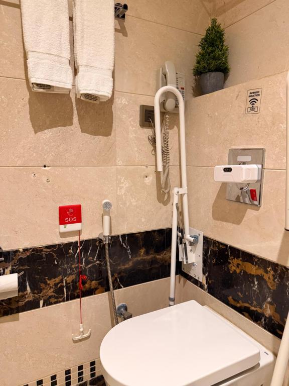 bagno con servizi igienici e asciugamani appesi alla parete di فندق الشهباء جده Al Shahba Jeddah a Gedda