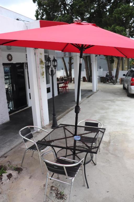 a table and chairs under a red umbrella at HW Hubers Laguboti in Laguboti