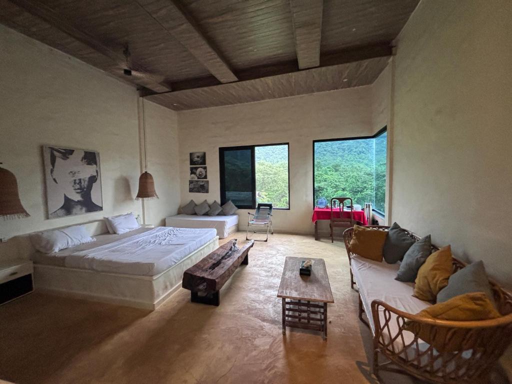 um quarto grande com uma cama e um sofá em Silvaate stay em Dhamni