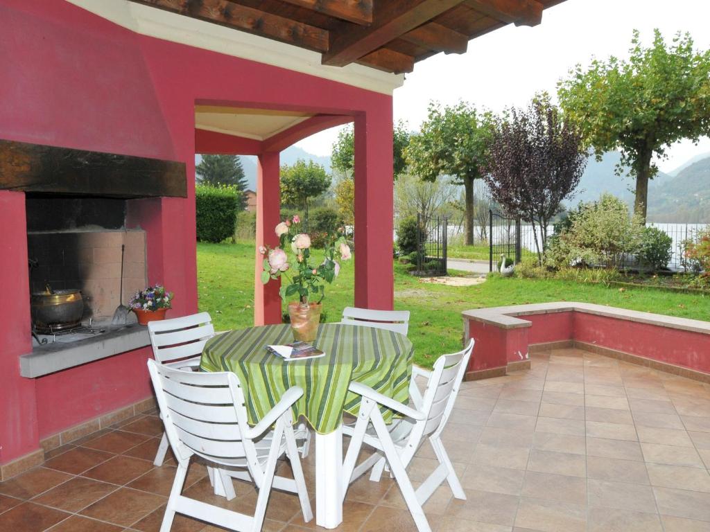 a table and chairs on a patio with a fireplace at Idyllic cottage next to the beautiful Lake Idro in Crone