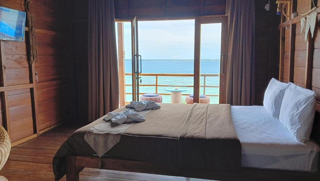 Casablanca Bira Resort في Tabutule: غرفة نوم مع سرير مطل على المحيط