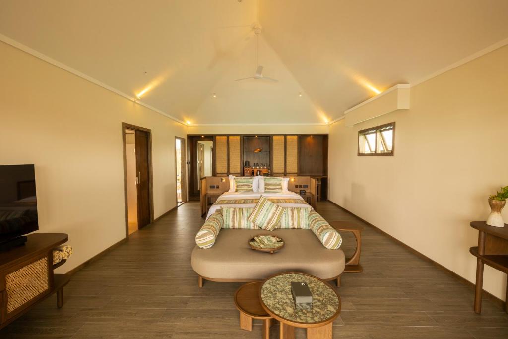 una camera d'albergo con un letto e un divano di Nala Maldives by Jawakara ad Atollo Lhaviyani