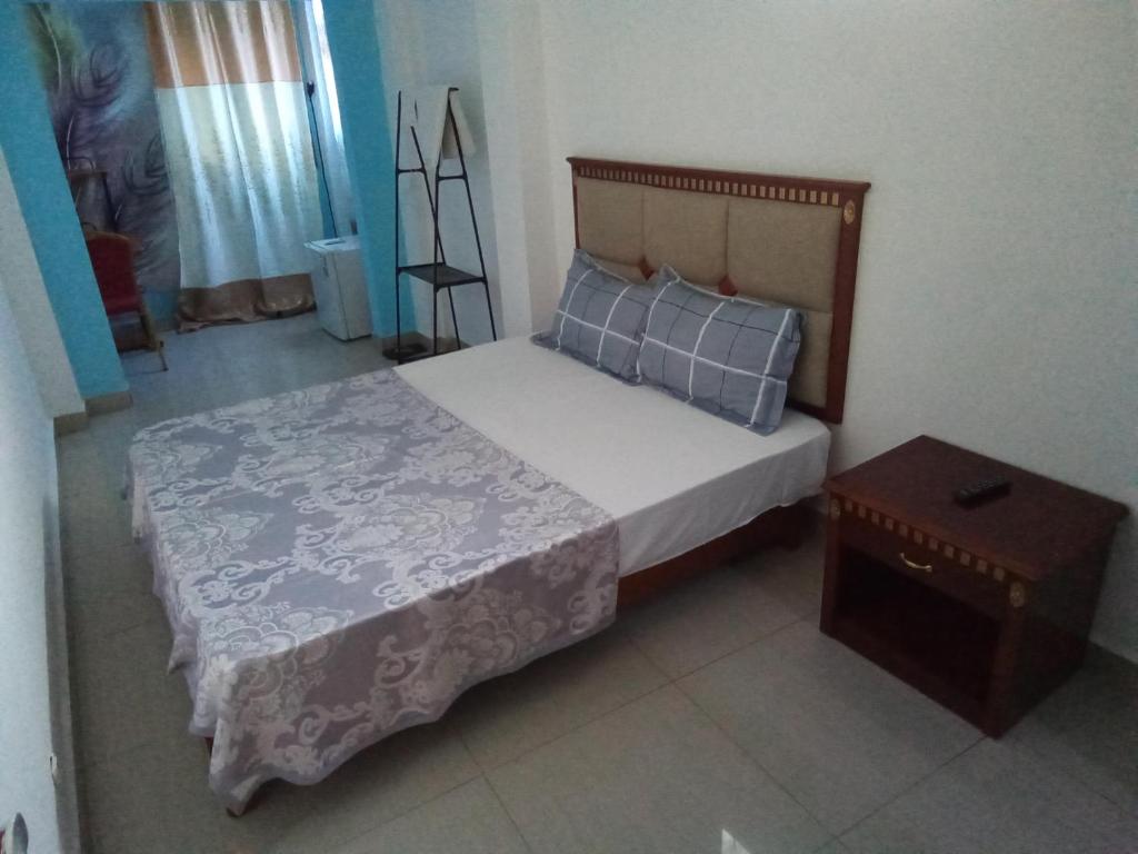 a small bedroom with a bed and a table at Mon soleil in Luanda