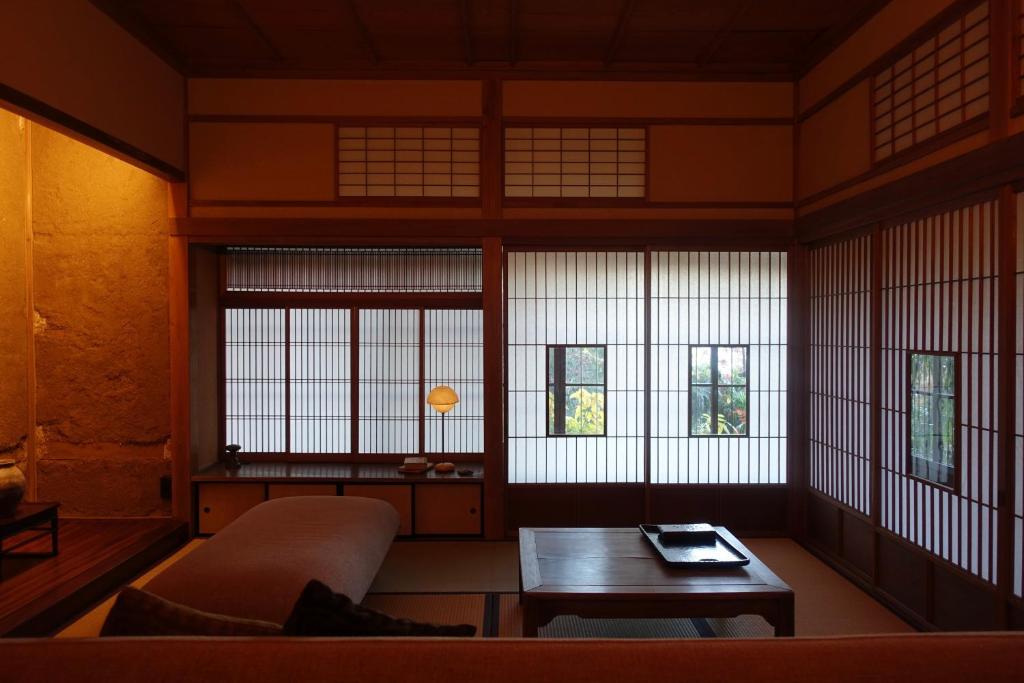 a room with a couch and a table and windows at 回青橙 daidai in Atami