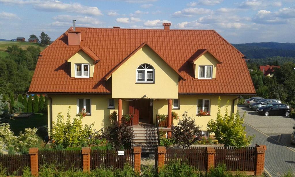 a yellow house with an orange roof at Dworek Julia in Polańczyk