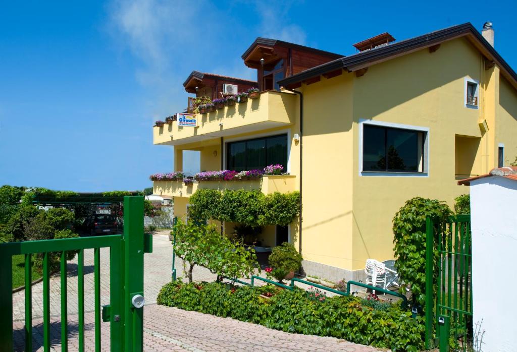una casa gialla con una recinzione verde di Casa Vacanze Il Girasole ad Agropoli
