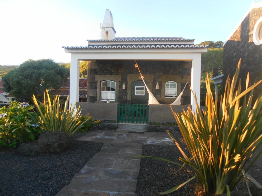 een achtertuin met een tuinhuisje en een aantal planten bij Casa Ilhéu - Fajã do Fisher in Feteira