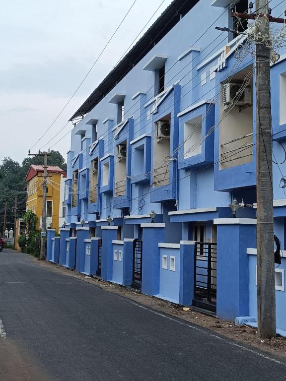 a blue building with lots of doors and windows at DPD Beach Hotel in Puducherry