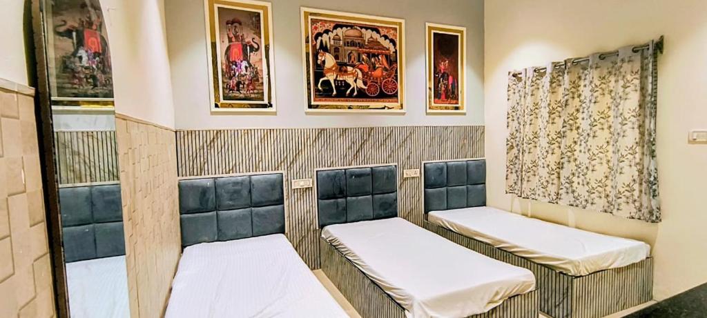 een rij stoelen in een kamer met schilderijen bij Hotel vk palace completly family stay #neartaj#luxurystay in Agra