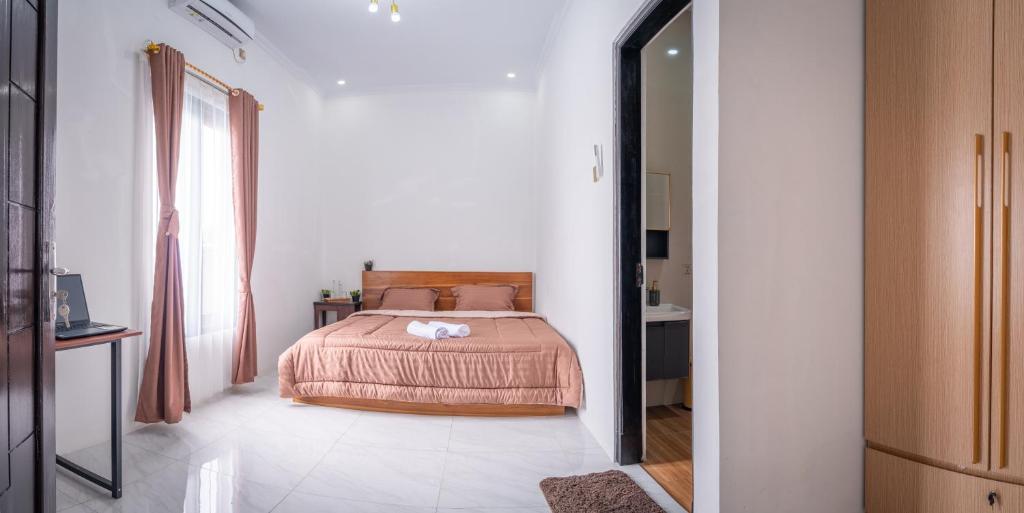 a bedroom with a bed and a large window at Micko Homestay, Mantrijeron "Top Rated Value" in Yogyakarta