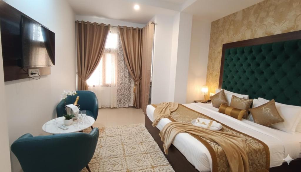 Una habitación de hotel con una cama, una mesa y sillas. en Hotel Lime Pride Park Near By IGI Airport Delhi, en Nueva Delhi