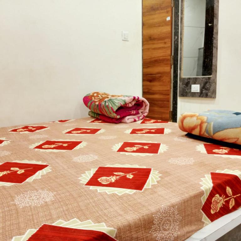 a bed with a comforter on top of it at Hotel M S in Pālia