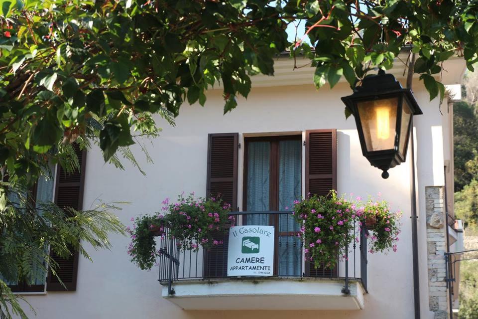 a building with a balcony with a sign and flowers at Il Casolare della Cascata in Terni