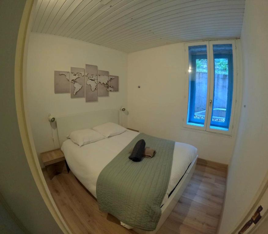 Un dormitorio con una cama con un sombrero encima. en Studio à 2 pas des thermes, en Saint-Martin-d'Uriage